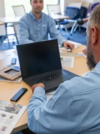 Clopay Architectural Design Support 200x267 A Clopay Architectural Design Support team member pointing to architectural drawings on a desk during a design consultation.