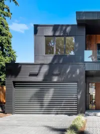 Clopay Canyon Ridge Modern Faux Wood Cladding- 200x267 A close-up of a Clopay Canyon Ridge Modern garage door, showing the detailed texture and warm tones of the faux wood cladding.