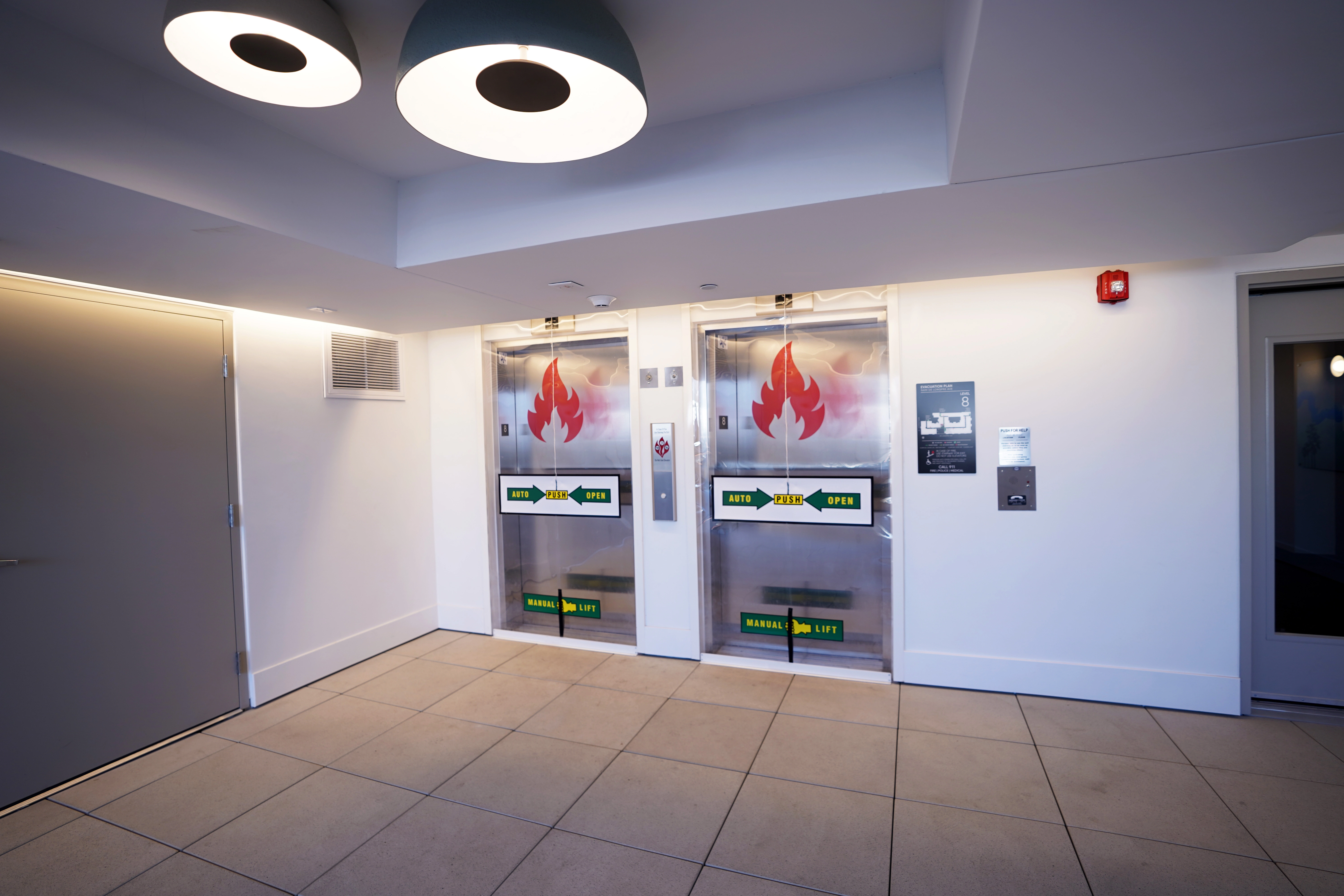 Deployed smoke curtain for elevator hoistway protection. SmokeShield Elevator Smoke Curtain providing code-compliant, life-safety protection by sealing an elevator hoistway from smoke migration in a data center lobby.
