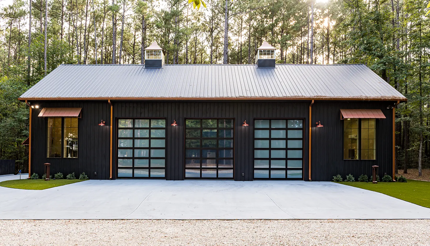 Clopay Avante garage doors with C-Power™ enabled Click-to-Conceal Panels with a black anodized frame and clear and white opaque glass
