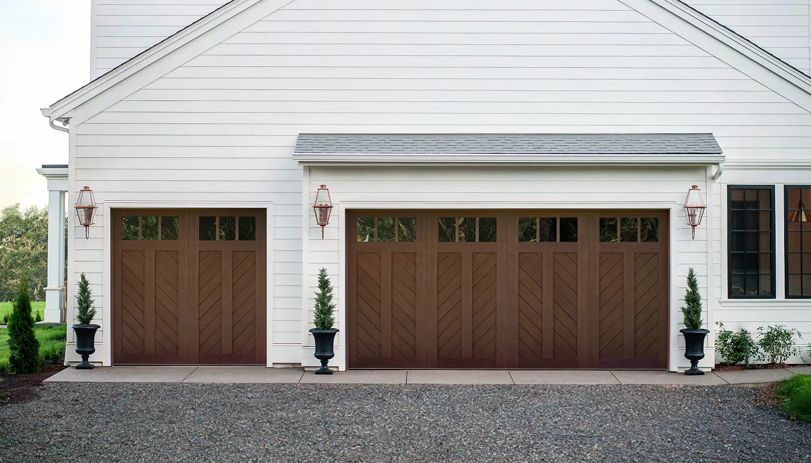 Canyon Ridge® Chevron garage door in Design 12 with REC13 windows in Walnut Finish